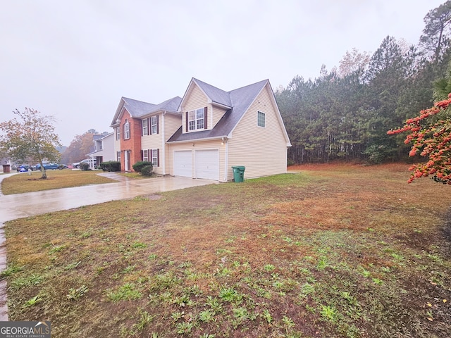 view of side of property featuring a garage and a lawn