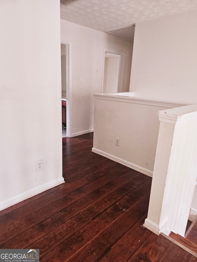 spare room with dark hardwood / wood-style flooring and a textured ceiling