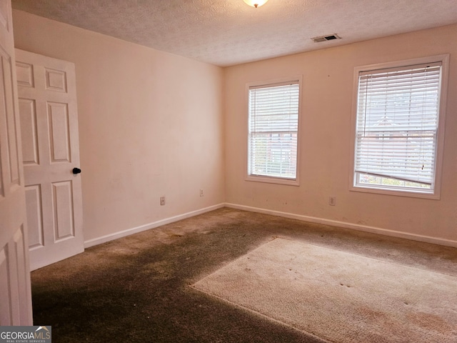 carpeted spare room featuring a textured ceiling