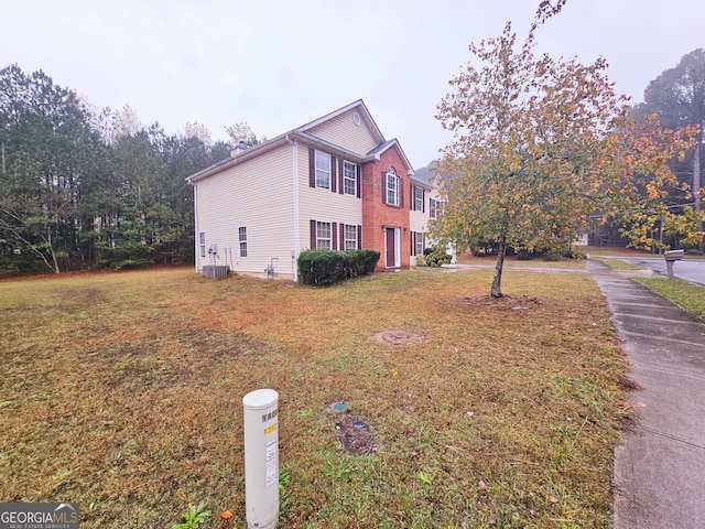 view of property exterior with a yard and central AC unit