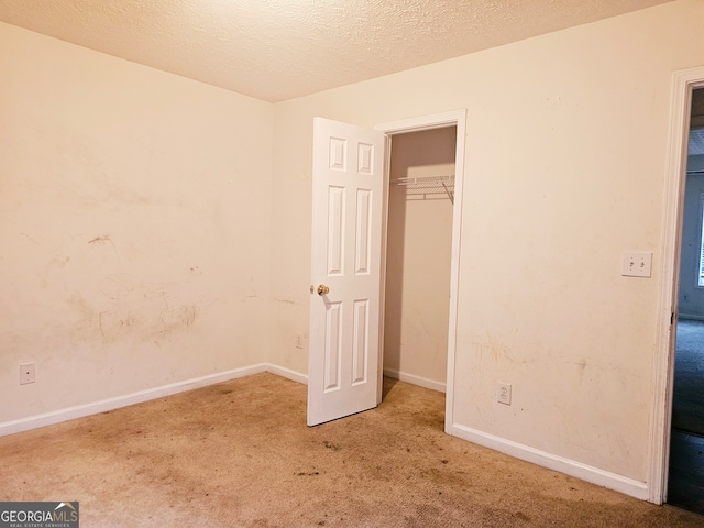 unfurnished bedroom featuring a textured ceiling and carpet floors