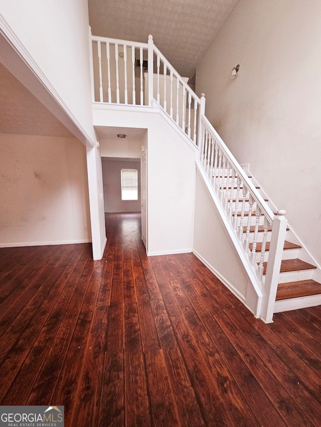 stairs featuring hardwood / wood-style floors and a towering ceiling