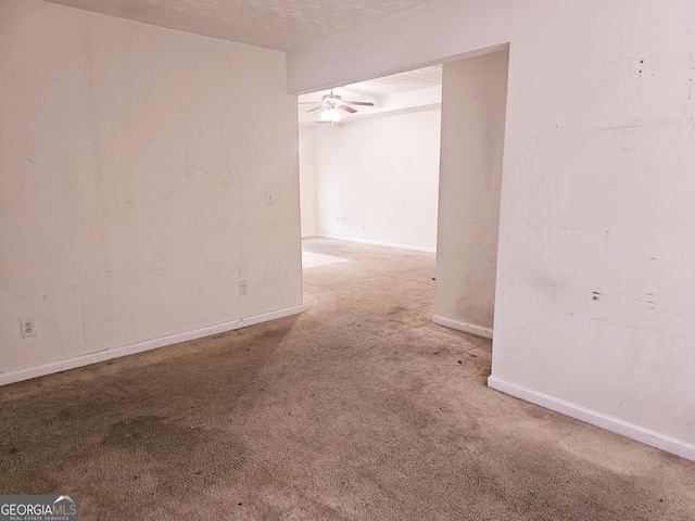 carpeted spare room with ceiling fan and a textured ceiling