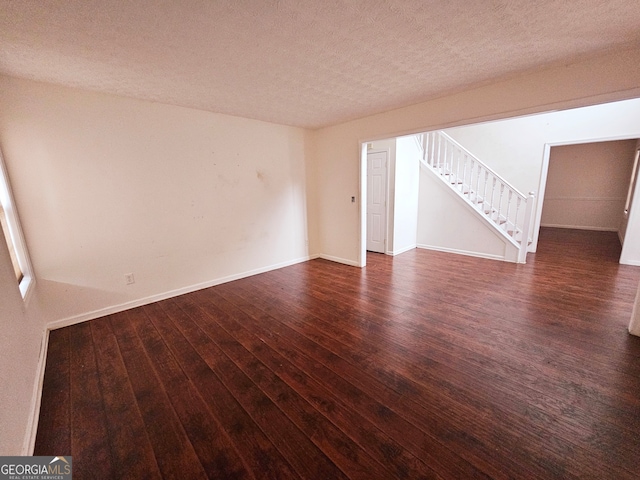 unfurnished room featuring a textured ceiling and dark hardwood / wood-style flooring