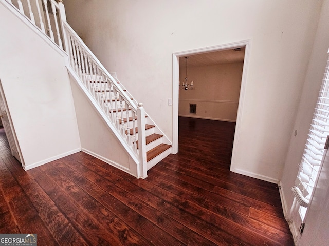 staircase featuring a chandelier and hardwood / wood-style flooring