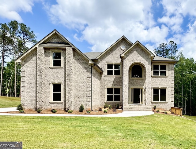 view of front facade featuring a front lawn, entry steps, and brick siding