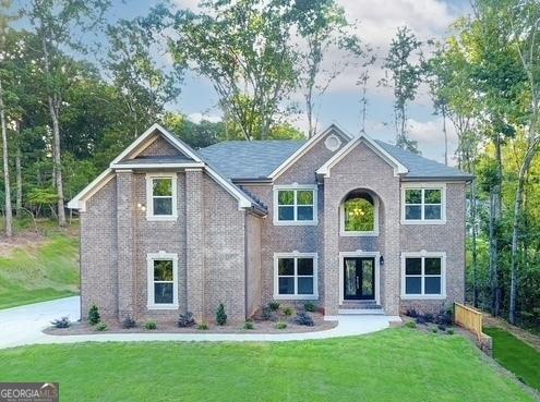 view of front of home featuring brick siding and a front yard