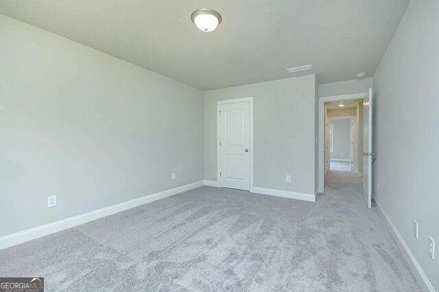 unfurnished bedroom featuring light carpet