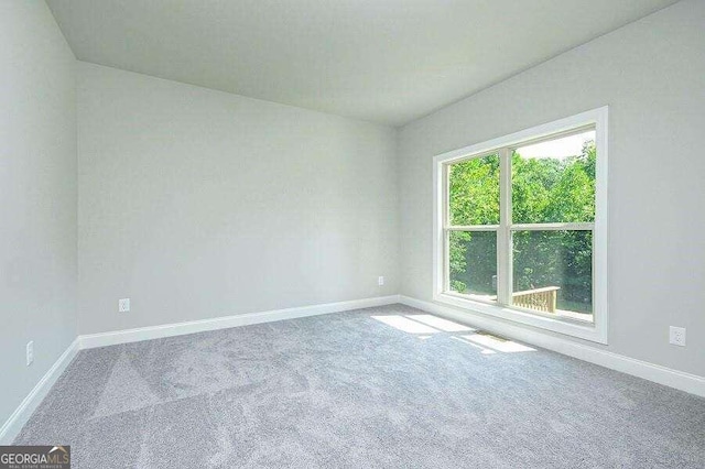 carpeted spare room with baseboards