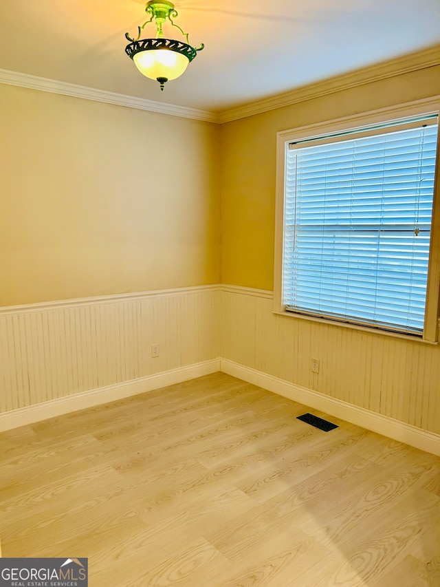 unfurnished room with hardwood / wood-style floors and crown molding