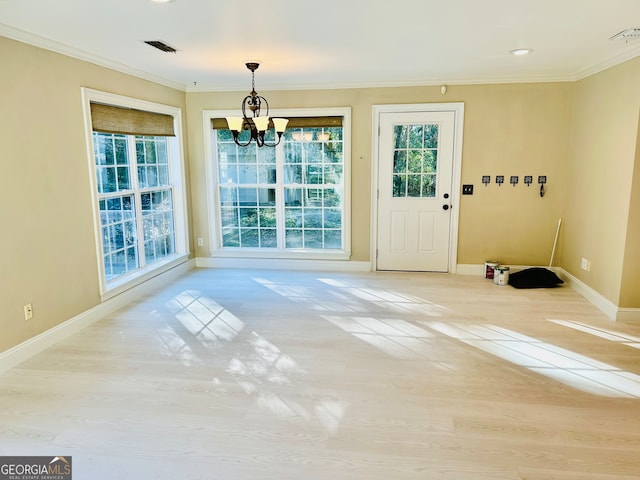 entryway with light hardwood / wood-style floors, crown molding, and a notable chandelier