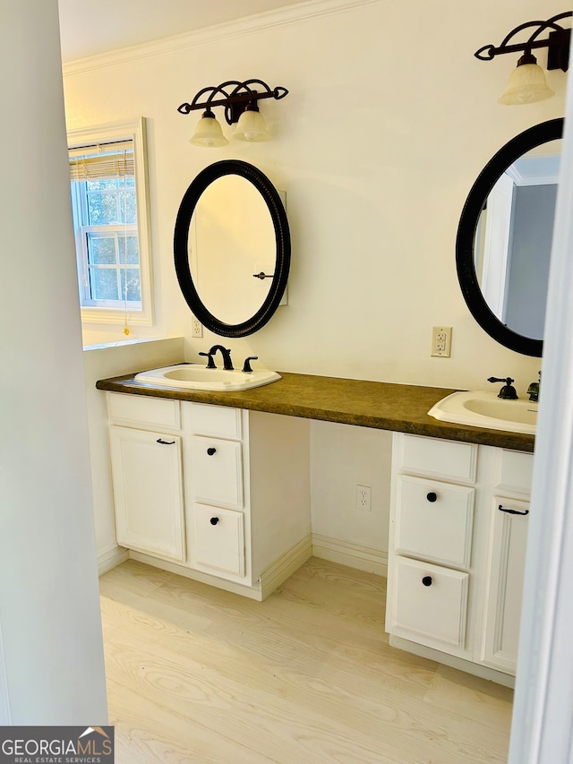 bathroom featuring hardwood / wood-style flooring, vanity, and crown molding