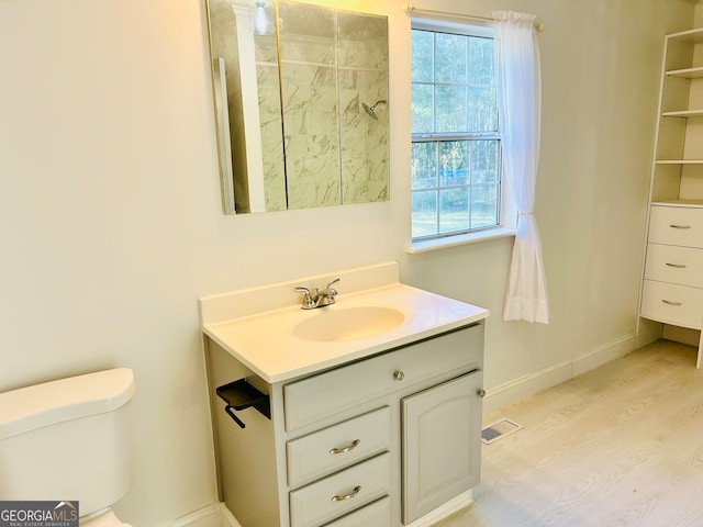 bathroom with hardwood / wood-style flooring, vanity, and toilet