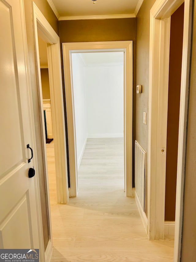 corridor featuring light hardwood / wood-style floors and ornamental molding