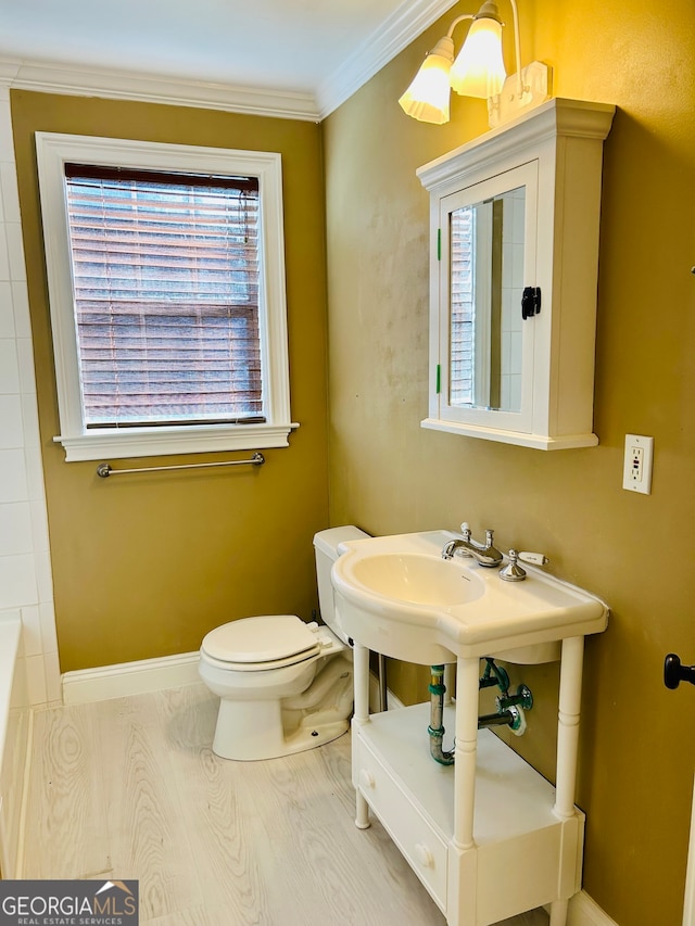 bathroom featuring crown molding, hardwood / wood-style flooring, and toilet