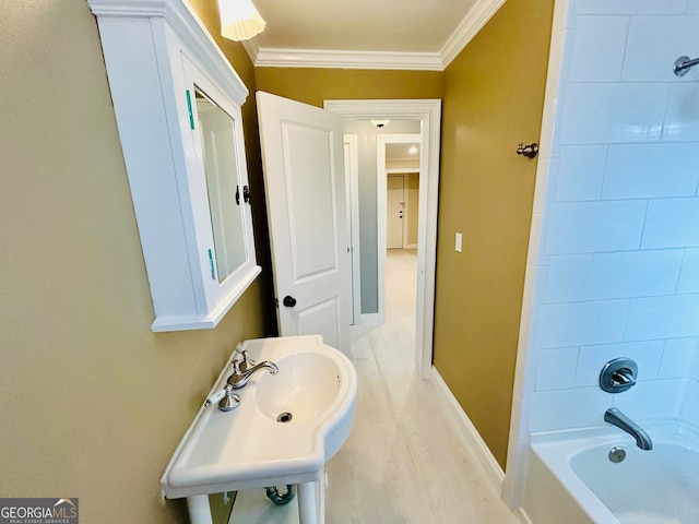 bathroom with tiled shower / bath combo, wood-type flooring, and crown molding