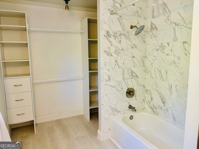 bathroom featuring crown molding, wood-type flooring, and tiled shower / bath combo