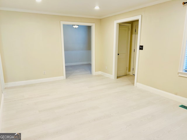 unfurnished room featuring crown molding and light hardwood / wood-style flooring