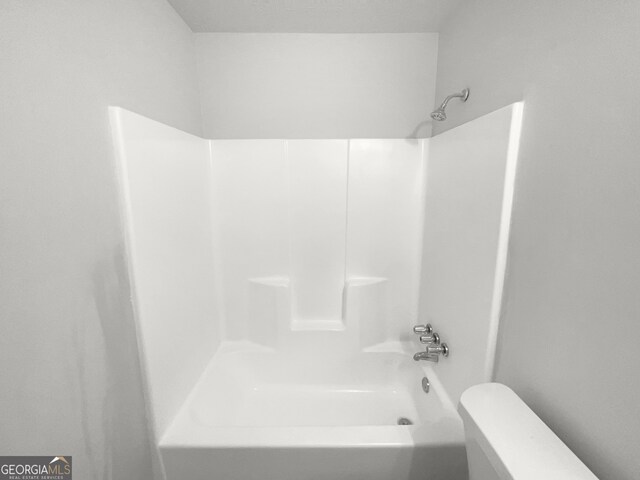 bathroom featuring shower / bathtub combination and toilet