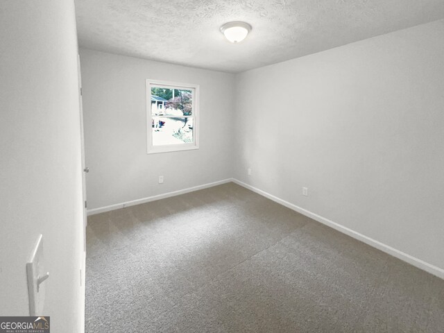 carpeted spare room featuring a textured ceiling