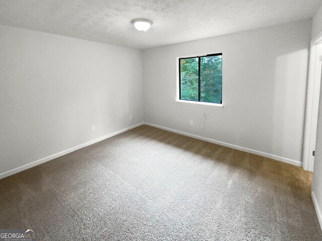 carpeted spare room featuring a textured ceiling