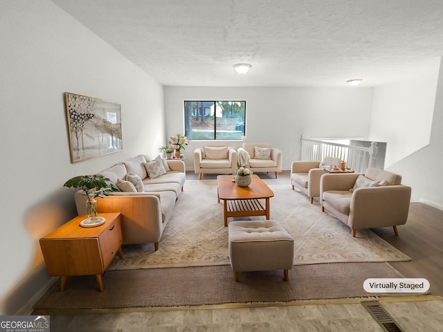 living room with a textured ceiling and light wood-type flooring