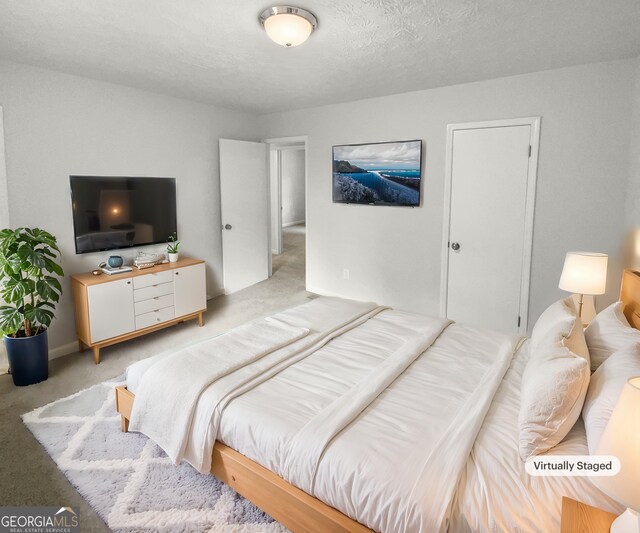 carpeted bedroom featuring a textured ceiling