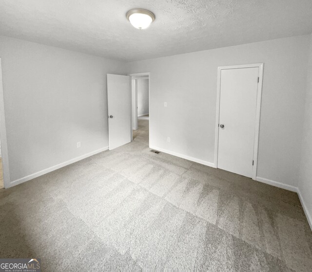 carpeted spare room featuring a textured ceiling