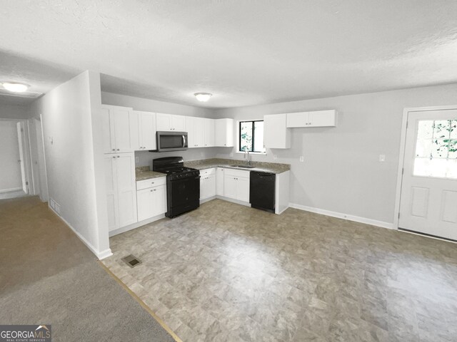 kitchen with sink, white cabinets, black appliances, and a textured ceiling