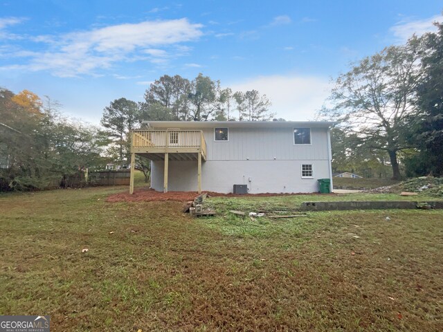 rear view of property with a wooden deck and a yard