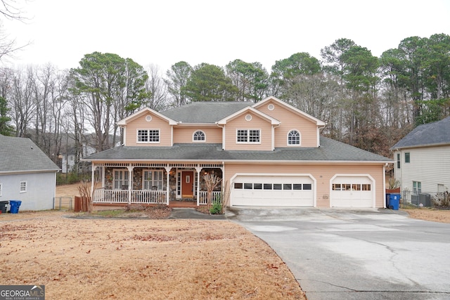 view of front property featuring covered porch, a garage, and central air condition unit