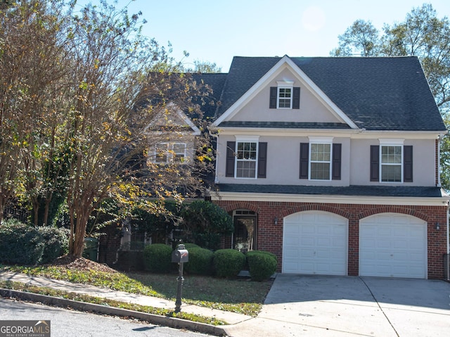 view of front facade with brick siding, an attached garage, concrete driveway, and a shingled roof