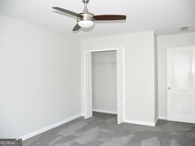 unfurnished bedroom featuring dark colored carpet, a closet, and ceiling fan