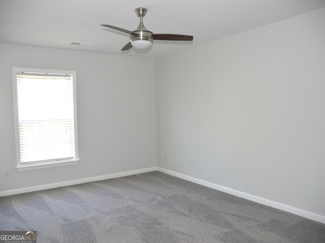 unfurnished bedroom with ceiling fan, dark carpet, and a closet