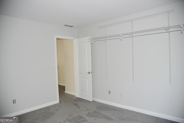 unfurnished bedroom with carpet floors and a closet