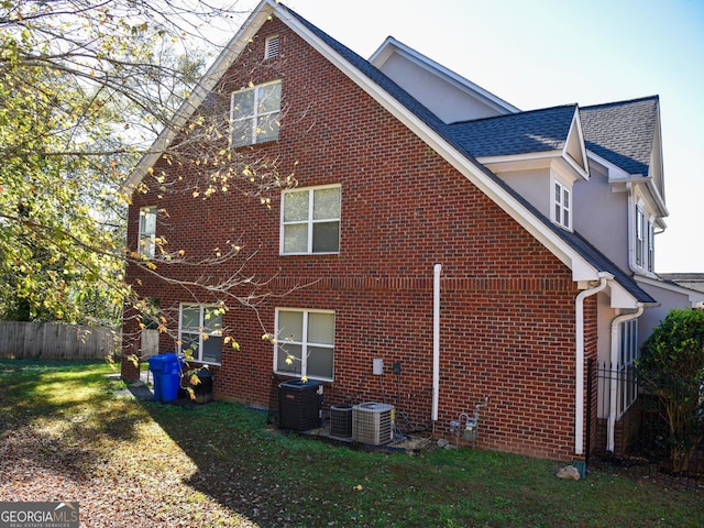 back of house featuring central AC and a yard