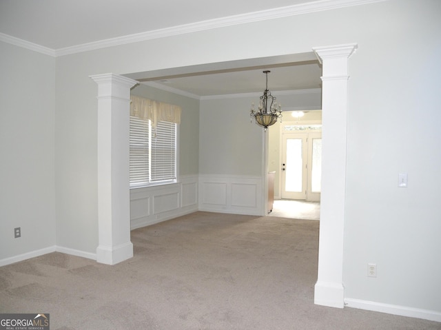 carpeted empty room featuring an inviting chandelier and ornamental molding