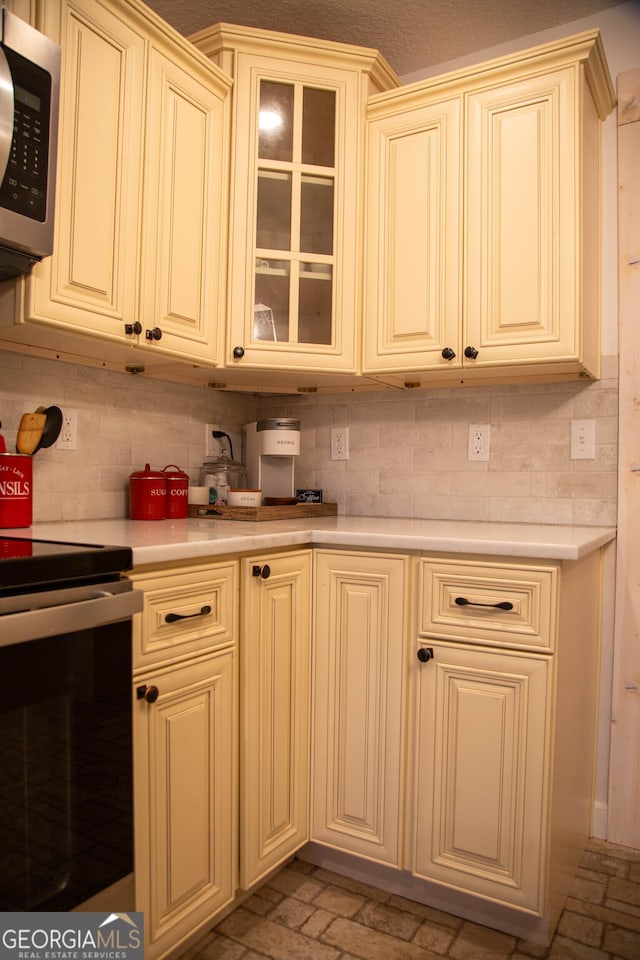 kitchen featuring tasteful backsplash, appliances with stainless steel finishes, and cream cabinets