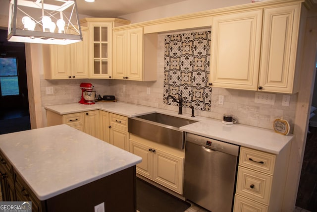 kitchen with tasteful backsplash, decorative light fixtures, dishwasher, and sink