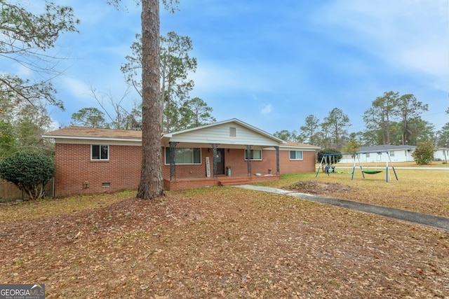 single story home with a trampoline, a front lawn, a playground, and covered porch