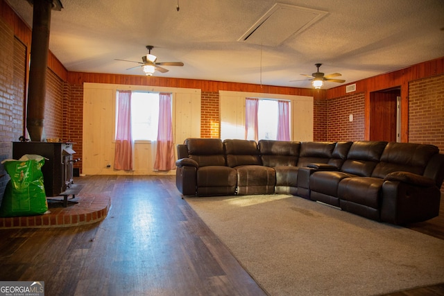 living room featuring plenty of natural light, a wood stove, and hardwood / wood-style floors