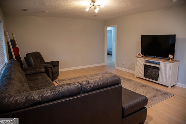 living room with a textured ceiling and light wood-type flooring