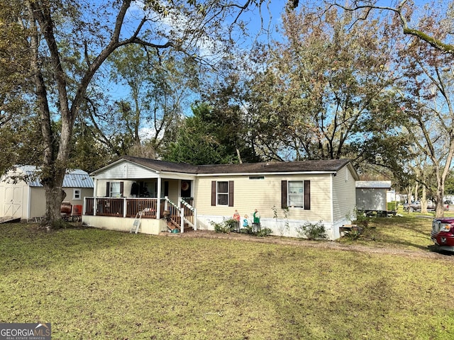 view of front of house with a front yard, a storage shed, and covered porch