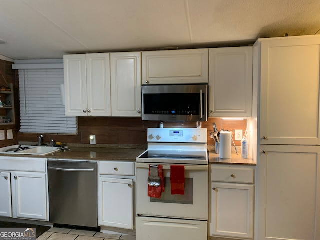 kitchen with appliances with stainless steel finishes, tasteful backsplash, white cabinetry, and sink