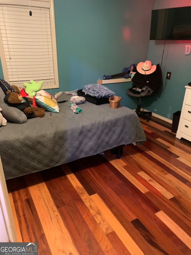 bedroom with dark hardwood / wood-style floors