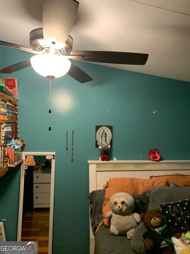 bedroom featuring hardwood / wood-style floors, ceiling fan, and lofted ceiling