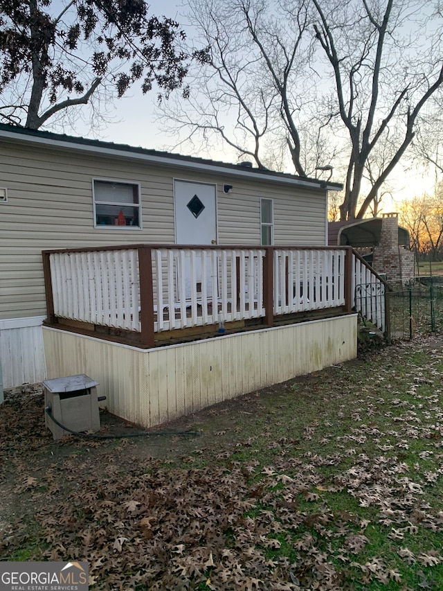 back house at dusk featuring a deck