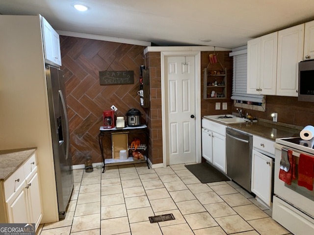 kitchen with tasteful backsplash, white cabinets, and stainless steel appliances