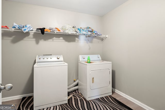 clothes washing area featuring wood-type flooring and independent washer and dryer