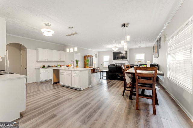 kitchen with light hardwood / wood-style floors, white cabinetry, a textured ceiling, and hanging light fixtures